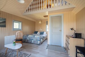 Un dormitorio acogedor con cama, una silla, un escritorio y un radiador.