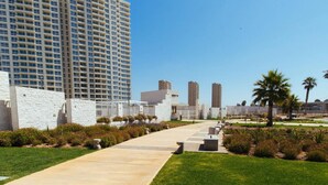 A pathway leading to a modern building with a white facade and a clear blue sky in the background. - Depto Euro Marina La Serena 1135 (Coquimbo)