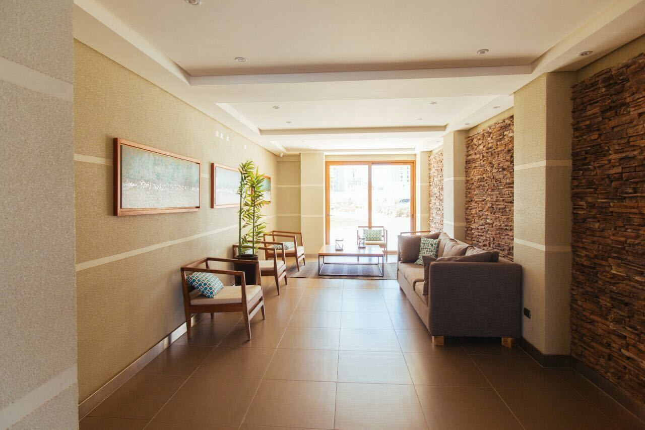A spacious living area with a sofa, chairs, a coffee table, and a potted plant.