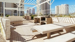 An outdoor seating area with concrete benches and a pergola structure. - Depto Euro Marina La Serena 1135 (Coquimbo)