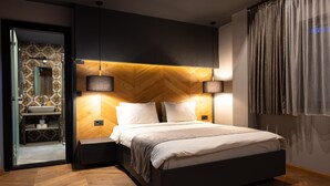 Ein modernes Schlafzimmer mit einem großen Bett, zwei Nachttischen, einer eingebauten Bank, einem Holz-Kopfteil und einem Spiegel.