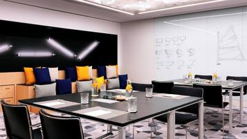 Una sala de conferencias moderna con una decoración en blanco y negro, suelo con estampado geométrico y una pizarra con bocetos de diseño.