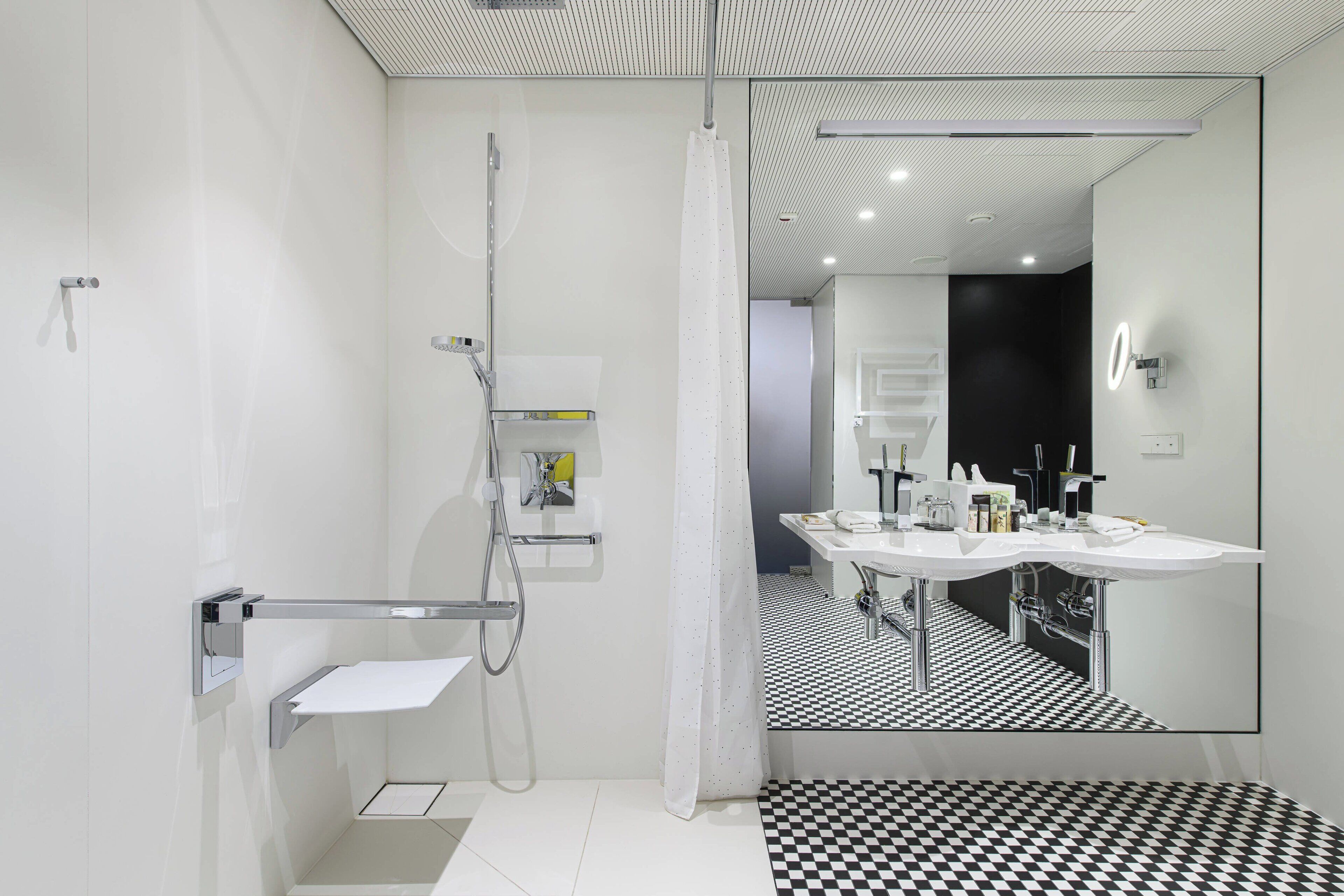 A modern bathroom with a shower, a sink, and a mirror.