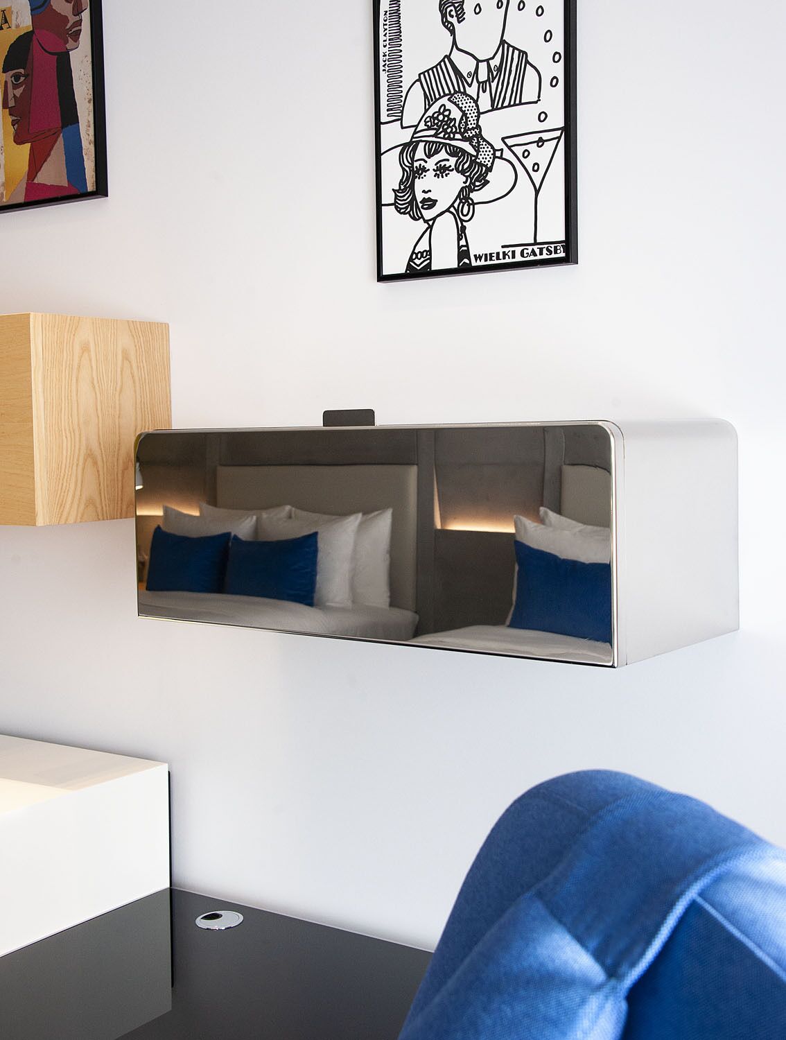 Een moderne kamer met een slaapbank, een houten accentmuur en een lijstwerk boven het bed.