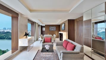A modern living room with a city view, a dining area, and a sofa with red cushions.