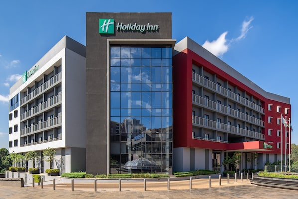 Un hôtel Holiday Inn au design moderne, caractérisé par une grande façade vitrée et de nombreux balcons.
