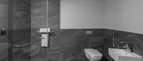 Une salle de bain moderne avec une douche à parois de verre, des toilettes et un lavabo.