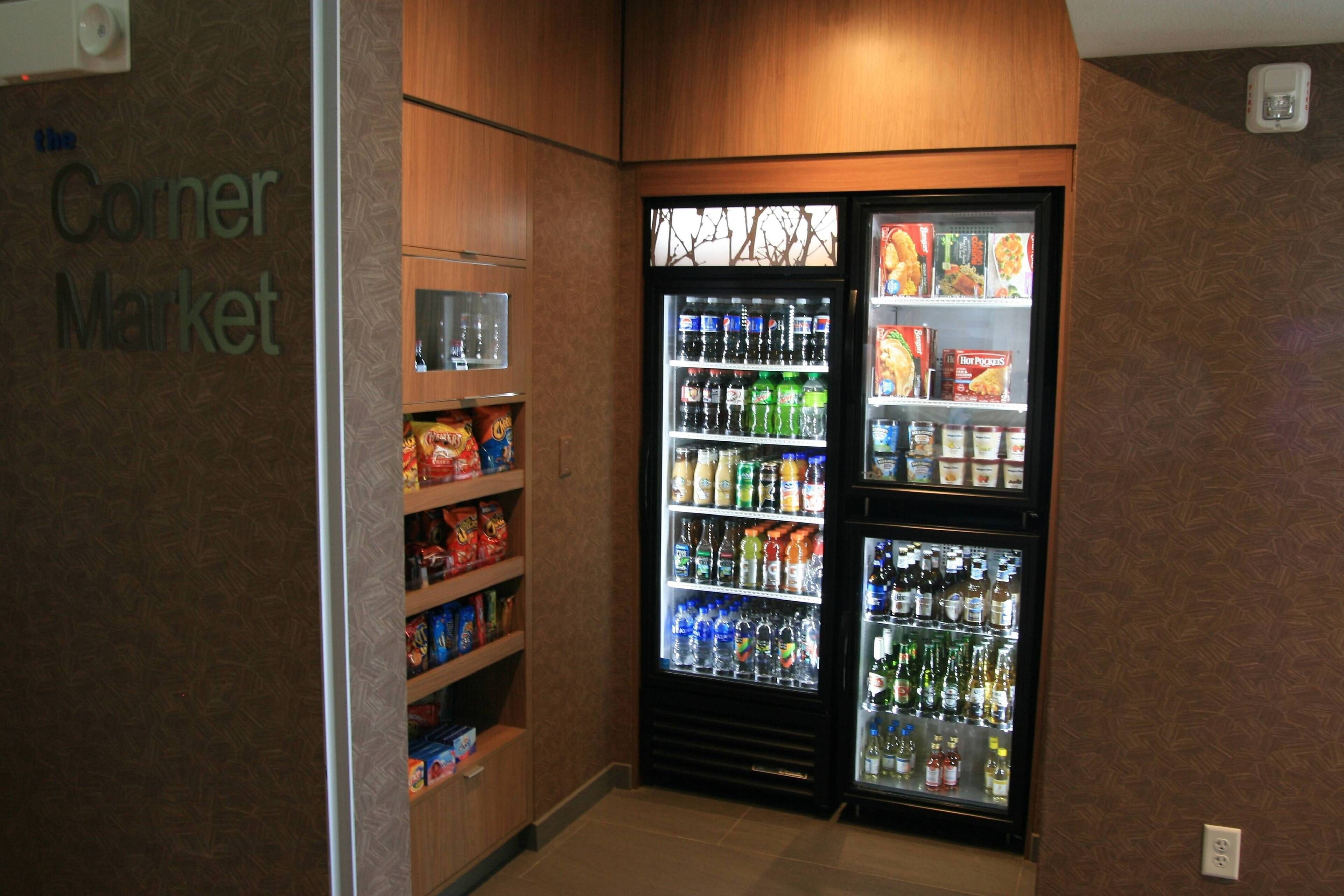 A corner market with refrigerated beverage dispensers and shelves stocked with snacks.