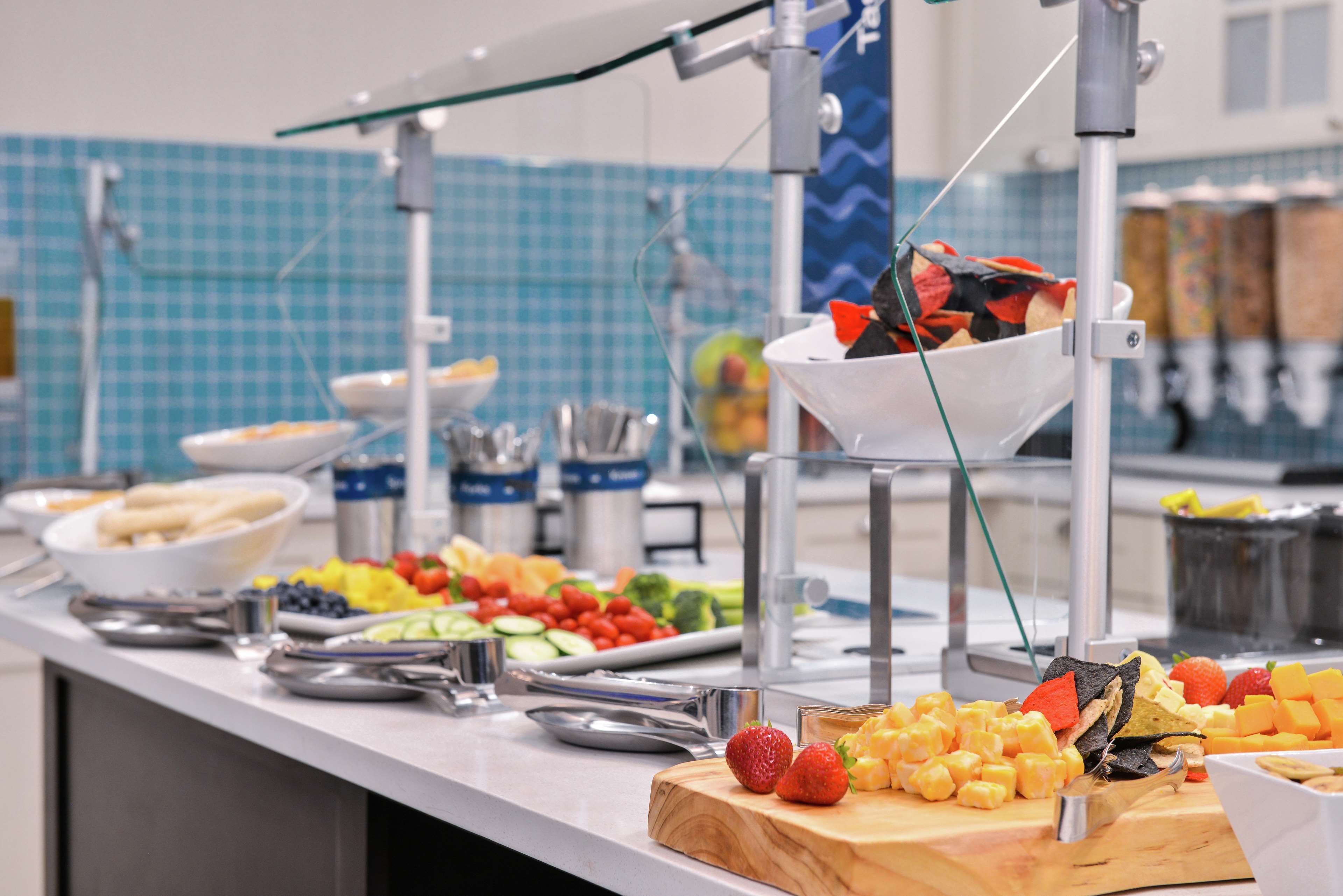 A buffet with various food items including fruits, vegetables, and cheese.