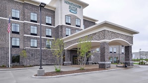 A hotel with a stone facade, a covered entrance, and an American flag.