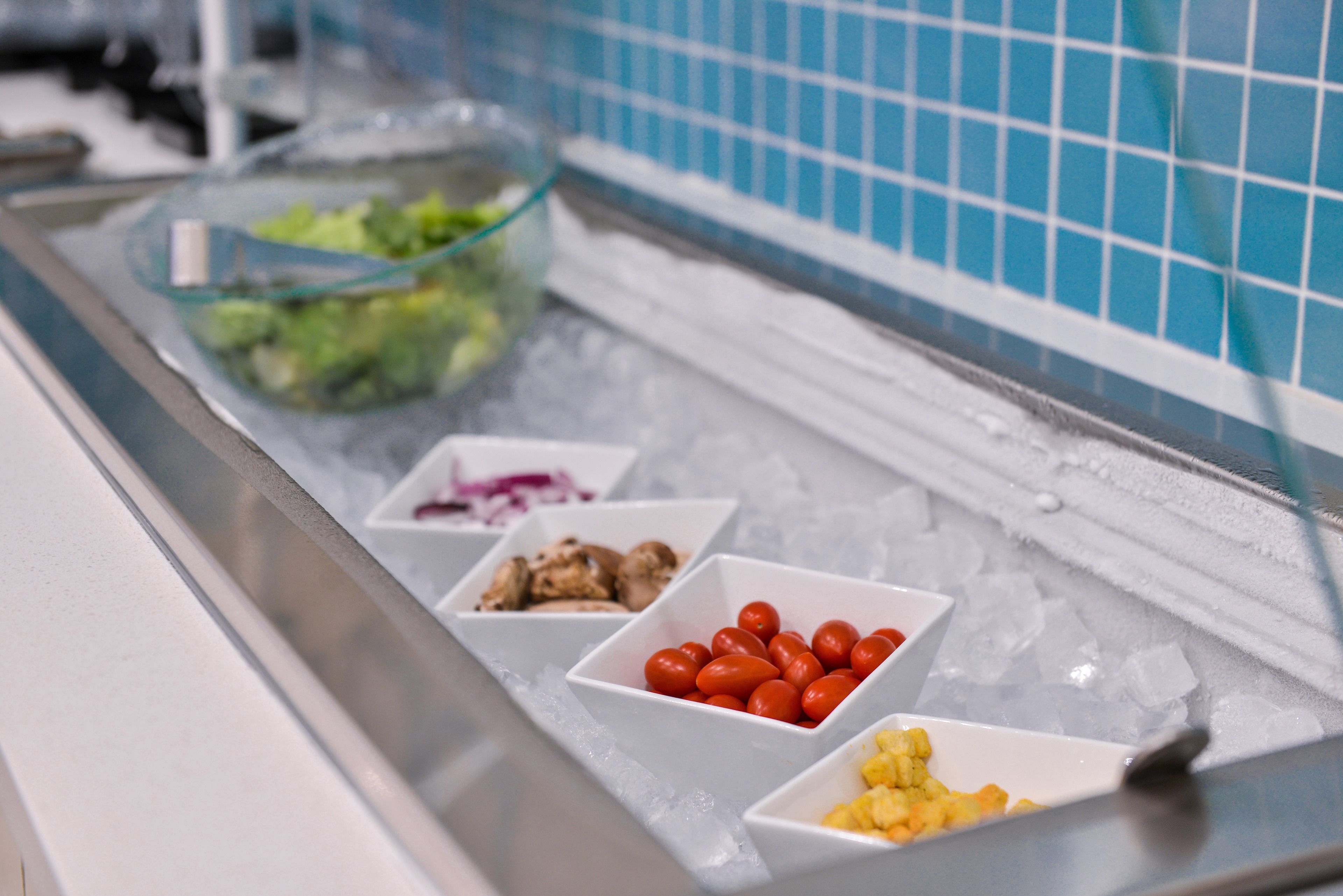 Un buffet proposant divers plats présentés sur des plateaux réfrigérés.