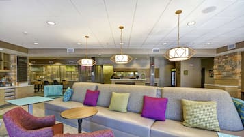 A modern lounge area with a sofa, chairs, and a small table.