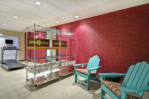 A fitness area with a treadmill, a spinning bike, and a spinning class sign. - Home2 Suites by Hilton Carbondale (Carbondale)