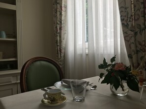 A dining table with a floral vase, a cup, and a glass. - Villa Pepoli (Occhiobello)