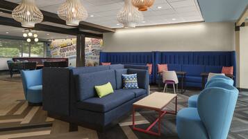 Un espace détente moderne avec des sièges bleus, une table basse et un éclairage décoratif.