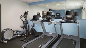 A fitness room with treadmills, an elliptical, and a stationary bike.