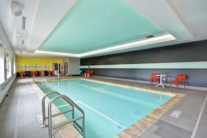 Una piscina techada, sillones reclinables de piscina