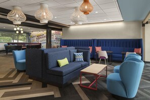 A modern lounge area with blue seating, a coffee table, and decorative lighting.