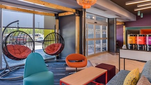 Un espacio lounge moderno con asientos cómodos, incluyendo un sofá, sillas y un banco.