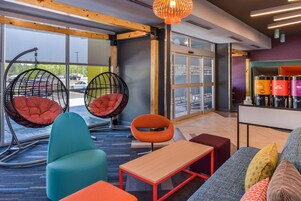 Un espacio lounge moderno con asientos cómodos, incluyendo un sofá, sillas y un banco.