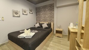 Quarto moderno com uma cama grande, cabeceira de madeira, parede decorada com padrão de tijolos e uma mesinha de cabeceira com chaleira.