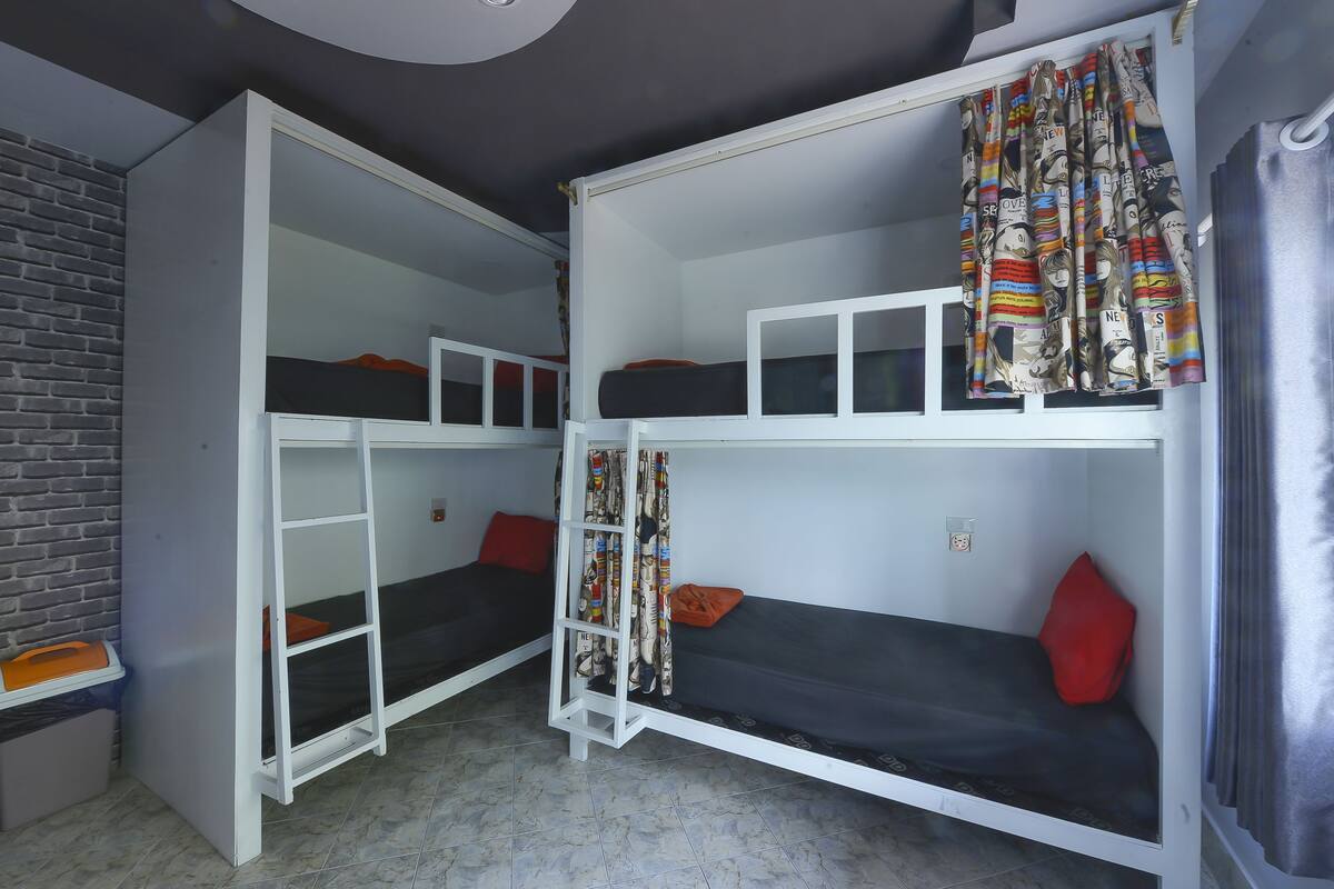A bunk bed room with a ladder, a desk, and a chair.