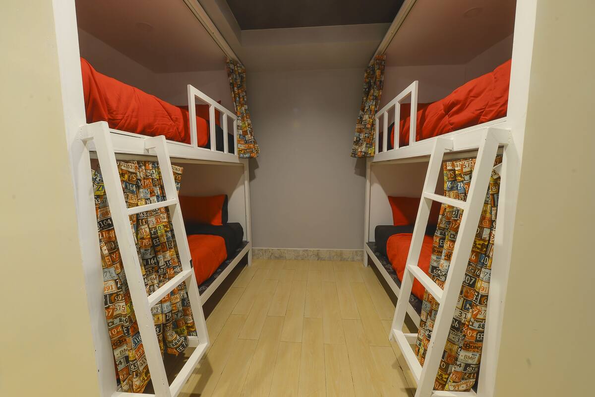 A room with bunk beds, each with a patterned curtain.