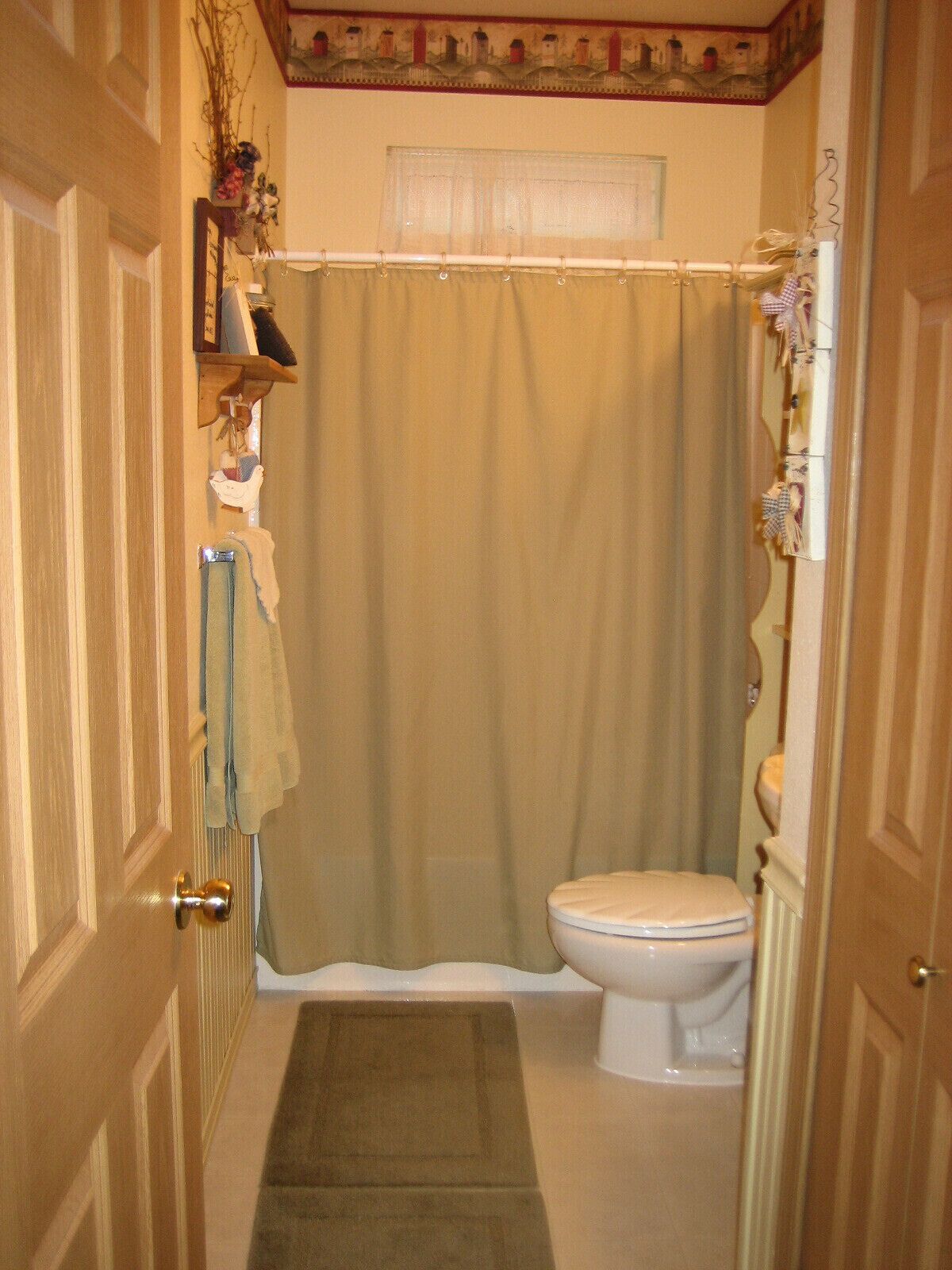 Ein Badezimmer mit Toilette, Duschvorhang und Handtuchhalter.