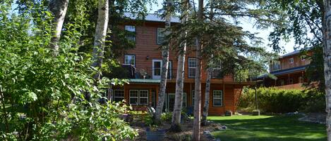 A two-story building with a red exterior, surrounded by trees and a well-maintained lawn.