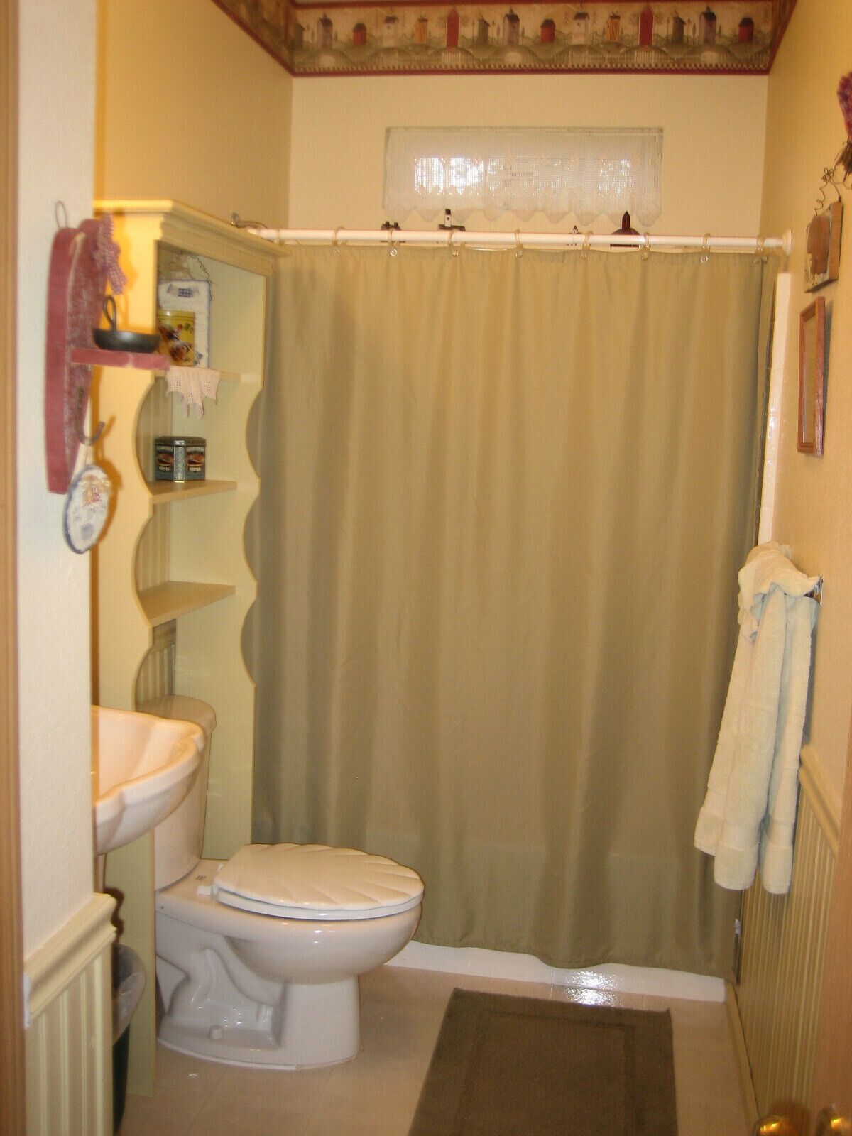 A bathroom with a toilet, sink, and shower curtain.