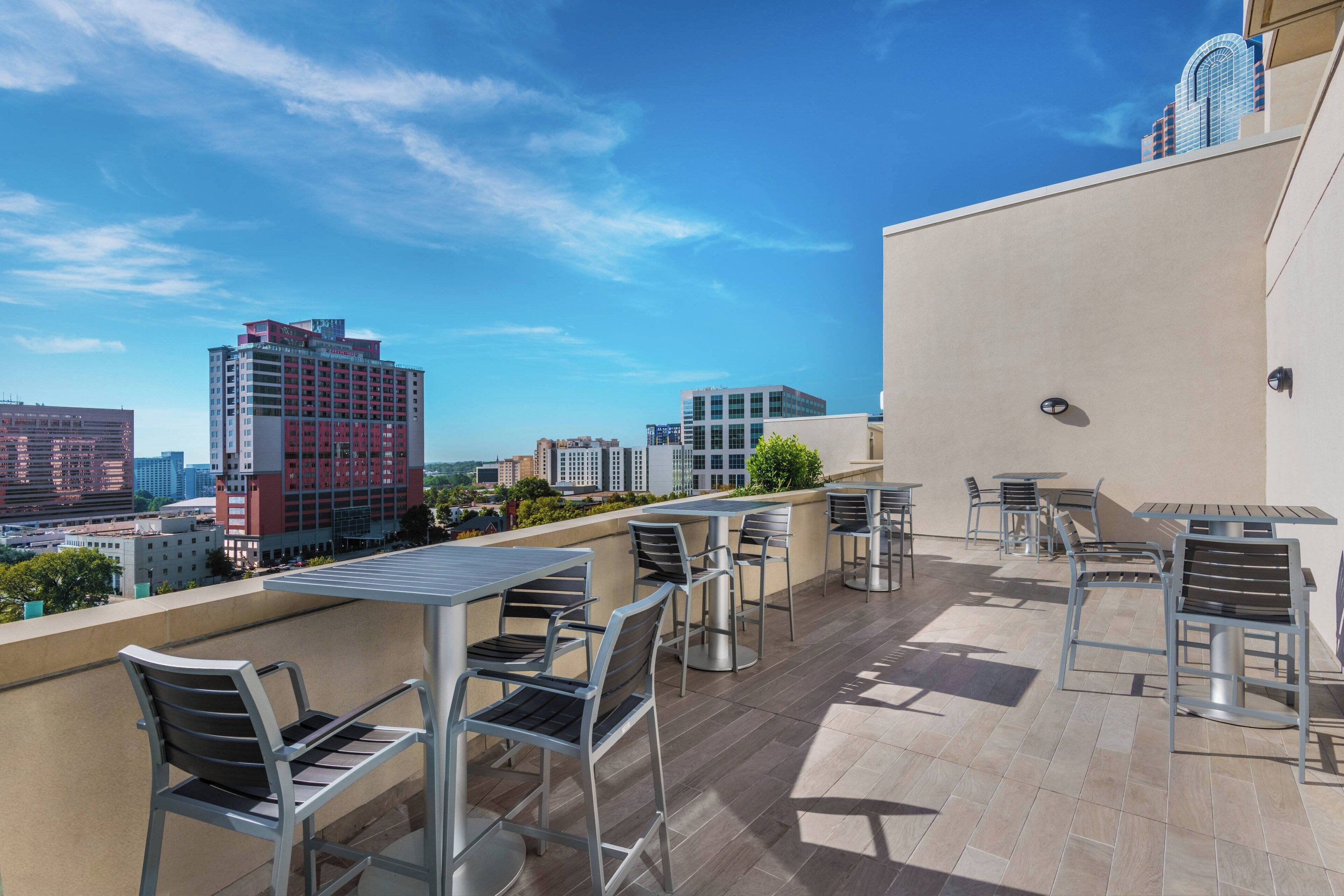 Terraza en la azotea con mobiliario exterior y vistas a la ciudad.