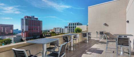 Terraza en la azotea con mobiliario exterior y vistas a la ciudad.