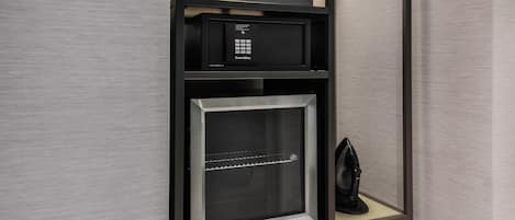 Un minibar compacto con cafetera, un dispositivo SmartBox y un mini refrigerador con puerta de vidrio.