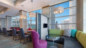 Une chambre d’hôtel moderne dotée d’un coin repas, d’un canapé et d’une télévision.