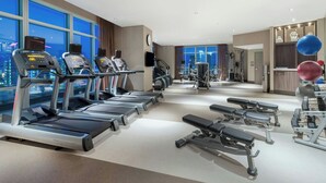 Une salle de sport moderne équipée de tapis de course, d’appareils de musculation et de ballons d’exercice.