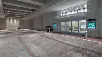 Un hall d’entrée spacieux au design moderne, comprenant un comptoir d’accueil, une plante et une signalétique pour les hôtels AC Hotels Marriott.