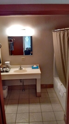 A bathroom with a sink, mirror, and shower curtain.
