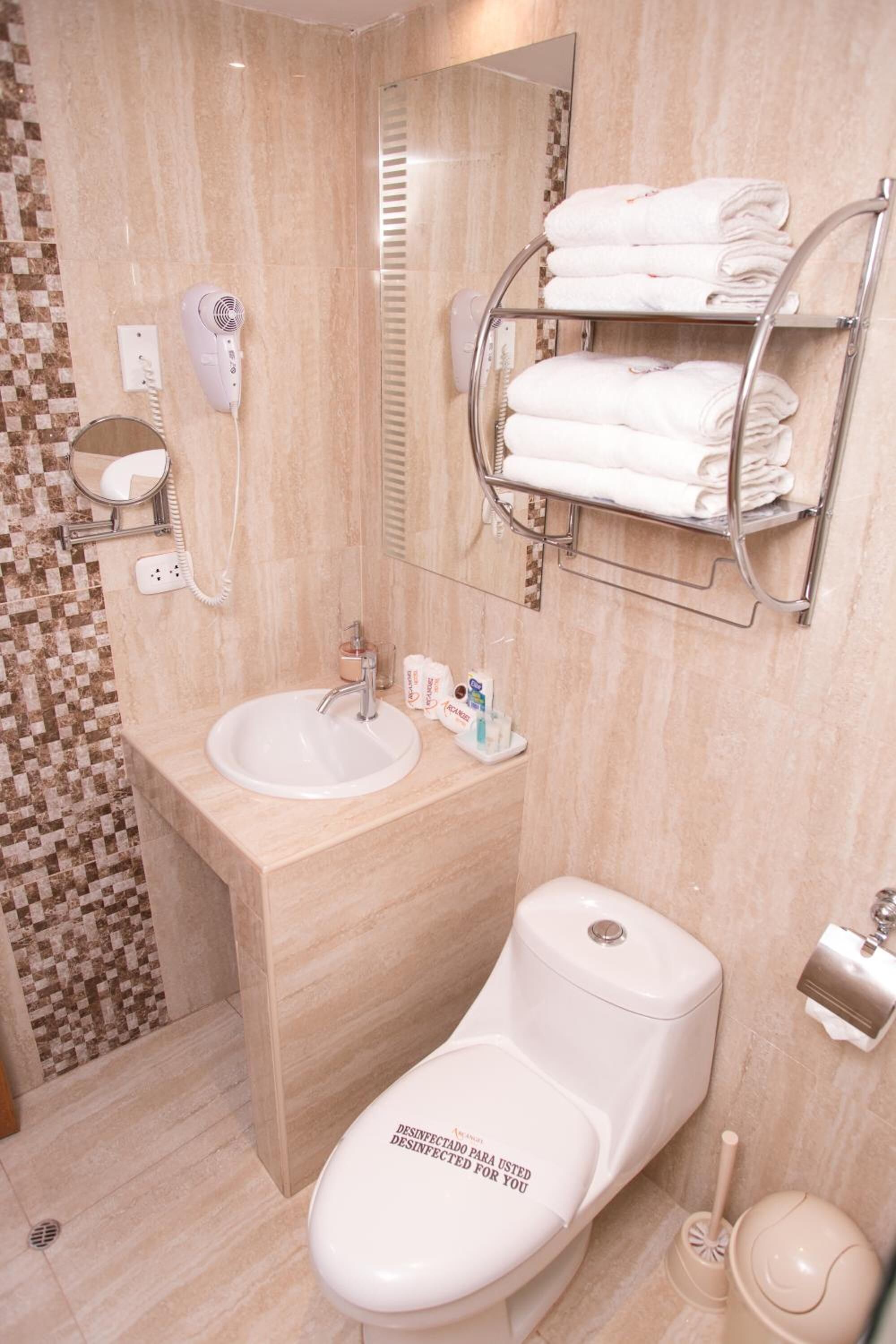 Uma casa de banho moderna com lavatório, sanita e suporte para toalhas.