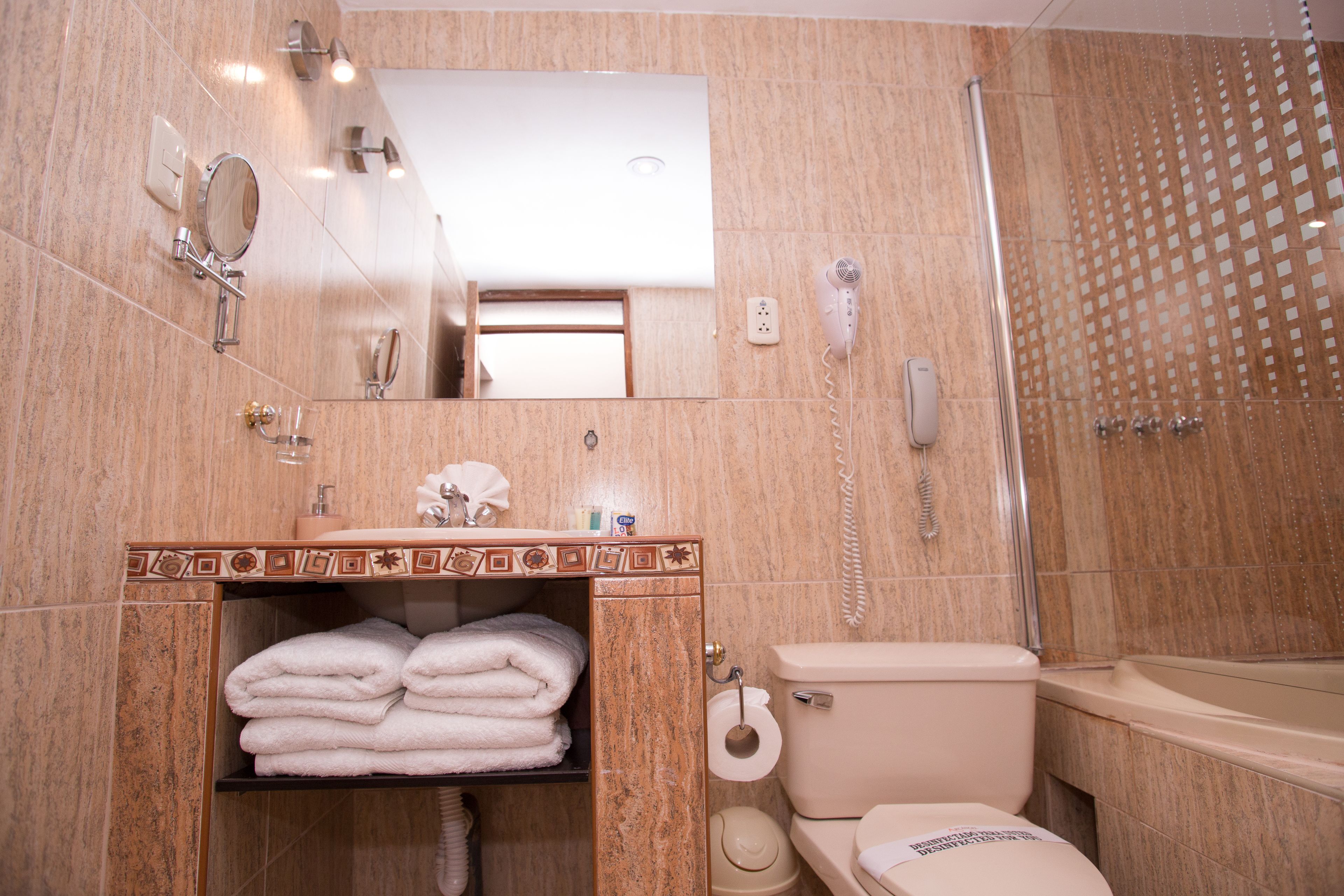 Un baño con inodoro, lavamanos y ducha.