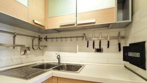Una cocina con un lavamanos doble, armarios de madera y un porta cuchillos.