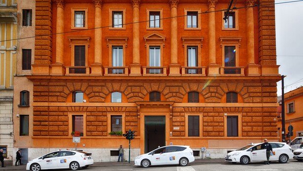Un edificio de varios pisos con fachada simétrica, ventanas amplias y una entrada central.
