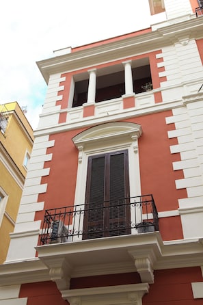 A building with a balcony, a window with shutters, and a decorative cornice. - Residence Maximus (Rome)