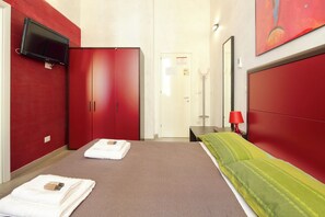 A hotel room with a bed, red wardrobe, and a TV mounted on the wall. - Residence Maximus (Rome)