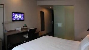 A hotel room with a bed, a desk, a chair, and a television on the wall. - Jinjiang Inn Select Dalian Youhao Square (Dalian)