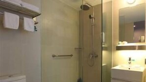 A modern bathroom with a glass-enclosed shower, a toilet, and a sink with a mirror above it. - Jinjiang Inn Select Dalian Youhao Square (Dalian)