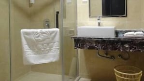 A modern bathroom with a glass shower enclosure, a sink with a marble countertop, and a mirror above the sink. - Hanmu Lanting Holiday Hotel (Nantong)