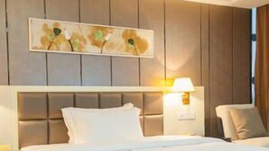 A hotel room with a bed, a nightstand, a lamp, and a painting on the wall. - Hanmu Lanting Holiday Hotel (Nantong)