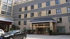 A multi-story hotel with a modern design, featuring a central entrance with glass doors and a flat roof. - Hanyun Huidu Hotel (Huaibei)