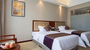 A hotel room with two beds, a wooden nightstand, and a painting on the wall. - Yuyuanhotel (Zhangzhou)