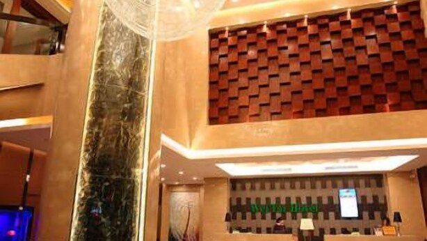 Et hotel lobby med receptionsdisk, en stor lysekrone og en indtjekningsdisk.